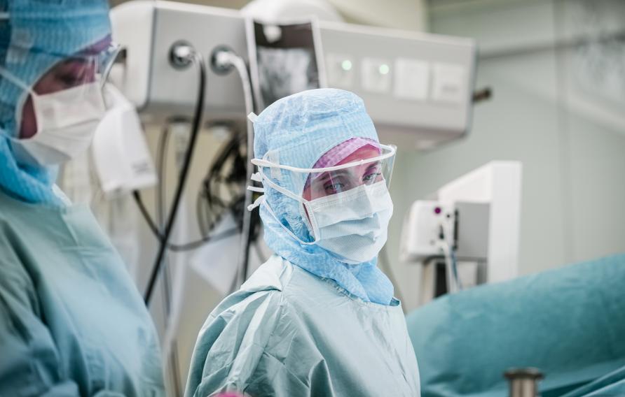 Female medical personnel in personal protective equipment in operating room