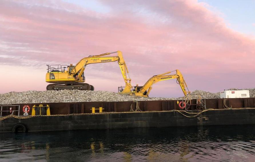 Two excavators at work on Windara Reef construction with pink sky at sunset behind them